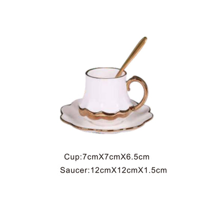 White ceramic cup and saucer set with golden pattern and handle