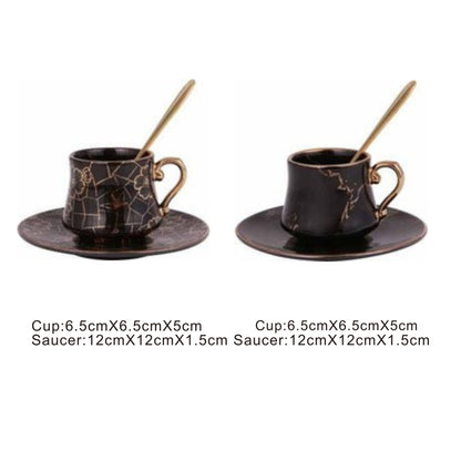 Black ceramic cup and saucer set with golden pattern and handle