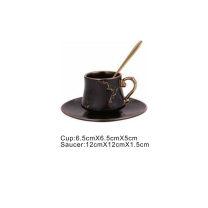 Black ceramic cup and saucer set with golden pattern and handle
