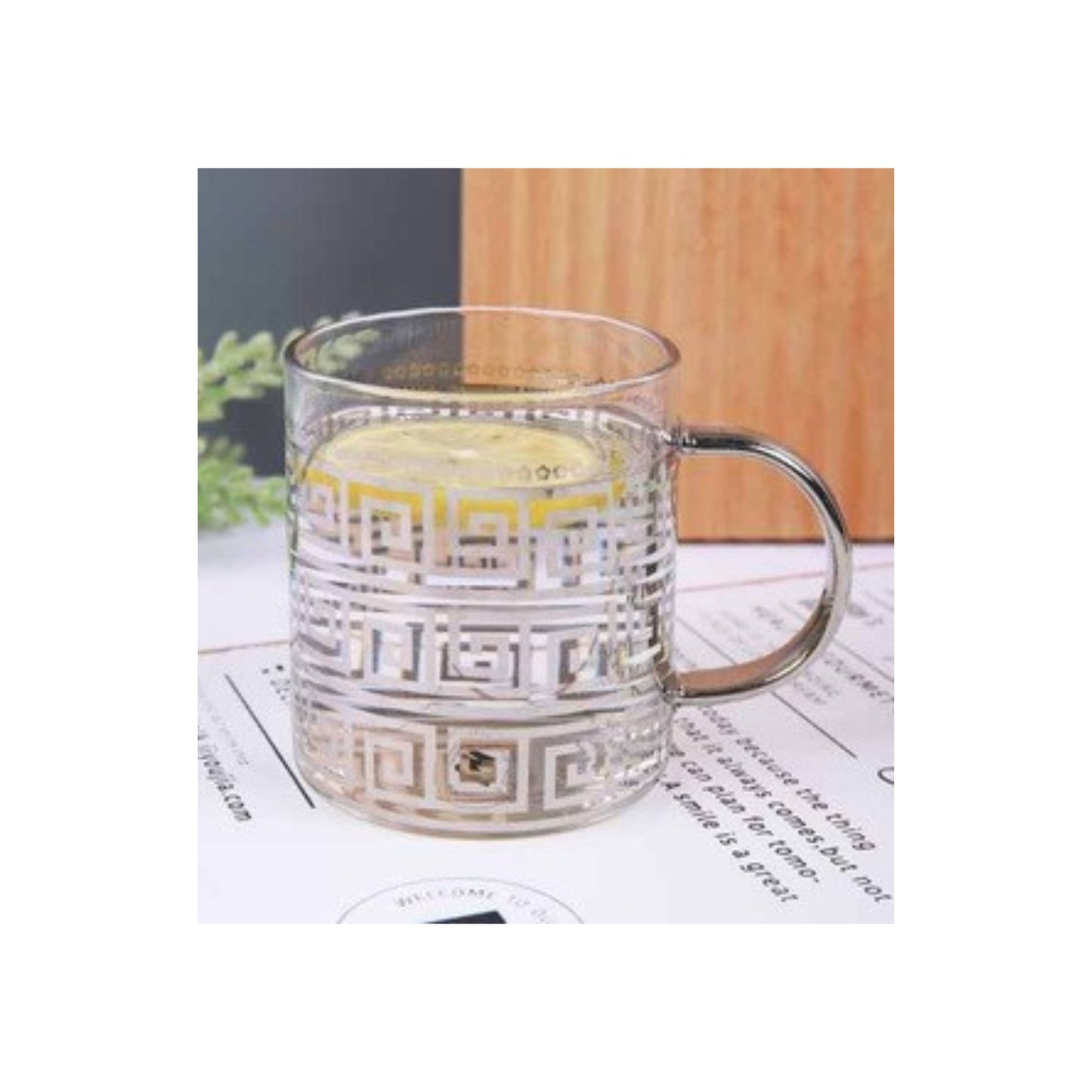 Glass mug with silver handle and silver maze pattern