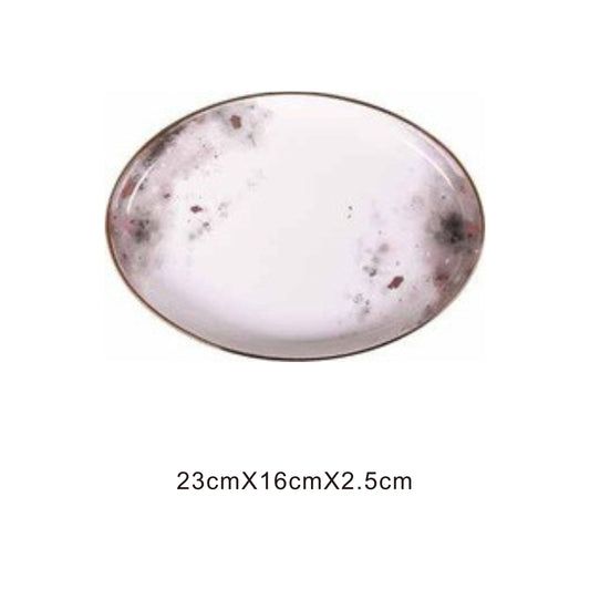 White ceramic plate with moon pattern, golden edges, and shiny surface