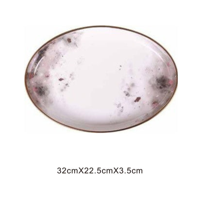 White ceramic plate with moon pattern, golden edges, and shiny surface